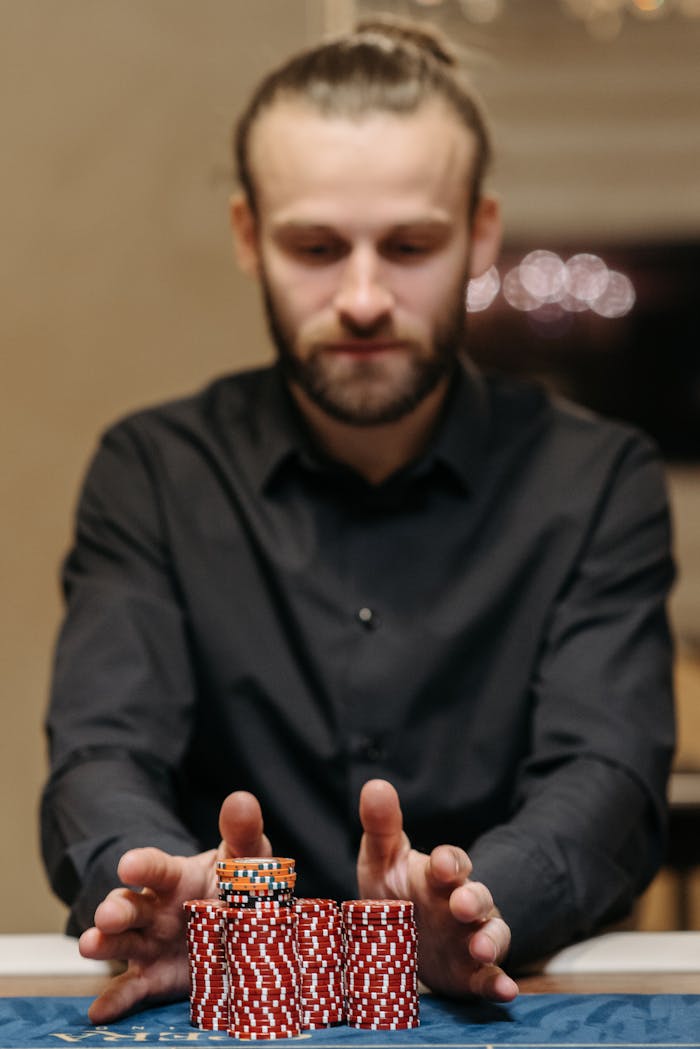 services-04 Focused man handling a stack of poker chips at a casino table, symbolizing gambling and risk.